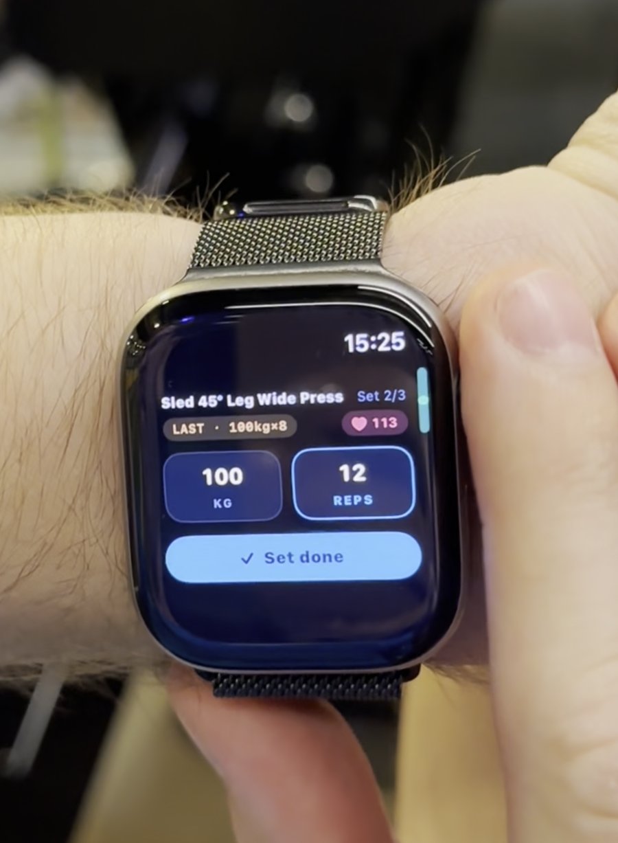 Musklrs aktivt sett-skjerm på Apple Watch under en beinpress, som viser 100 kg og 12 repetisjoner med en Sett gjort-knapp.